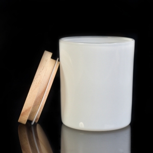 białe szklane świeczniki z drewnianymi wieczkami