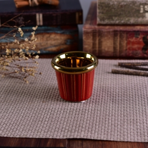 Un porte-bougies en céramique verni et doré