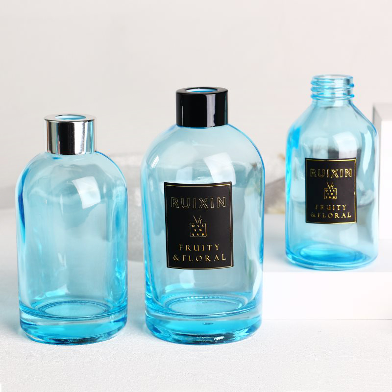 Botellas difusoras redondas de color azul claro con etiquetas, tapas y cuello de rosca