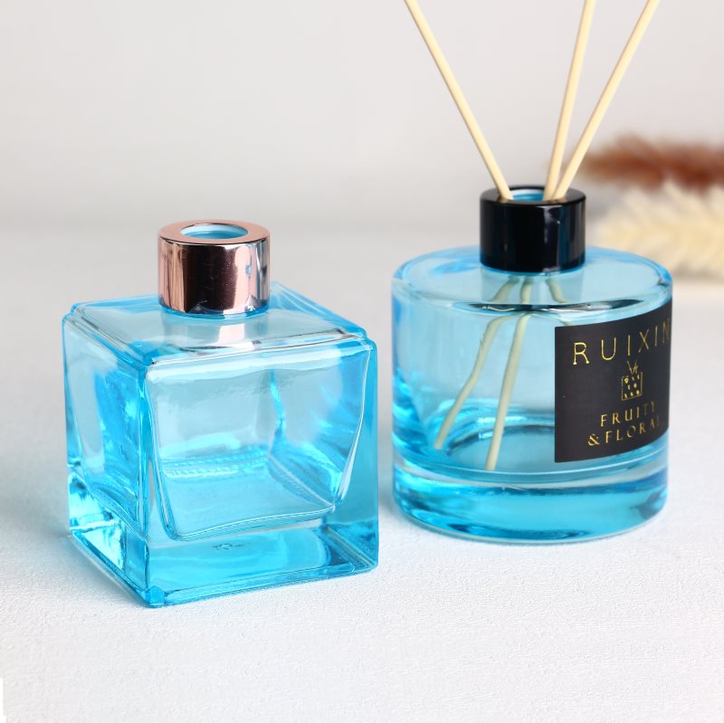 Vierkante lichtblauwe glazen diffuserflessen met etiketten en doppen