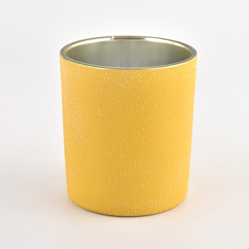 Kerzenbehälter aus Glas mit gelber Sandbeschichtung und silberner Innenseite