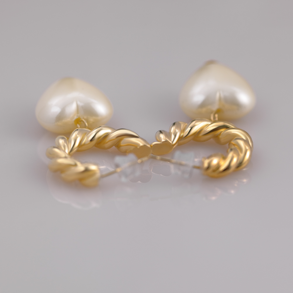 Boucles d'oreilles créoles demi-C en laiton plaqué or torsadé et perles en forme de cœur.