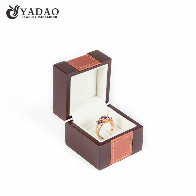 Luxusní ručně vyráběná dřevěná hnědá prstenová krabička pokrytá koženkou vhodná pro balení a vystavování jemných šperků.