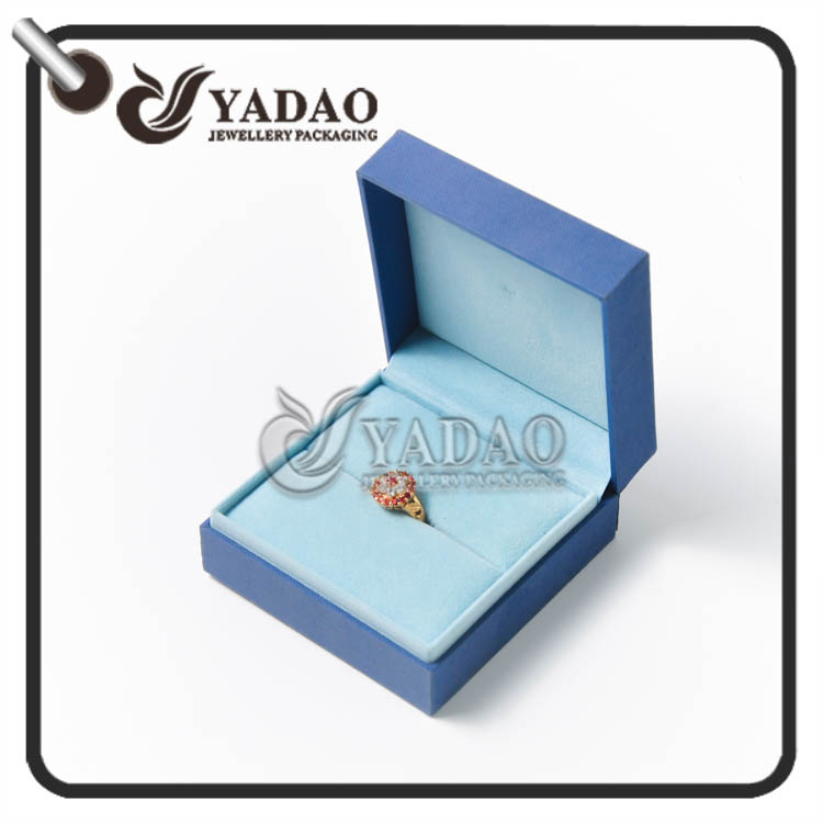 Grande caixa do anel coberta com o papel azul do plutônio com o interior macio do veludo apropriado para o anel e o pacote do brinco.