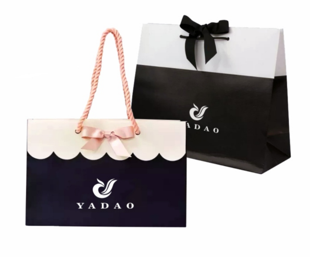 Sacchetto di design personalizzato di Yadao Personalizzato CMYK Stampa Borsa di carta Shopping Borsa da imballaggio con la chiusura del nodo di prua per il regalo