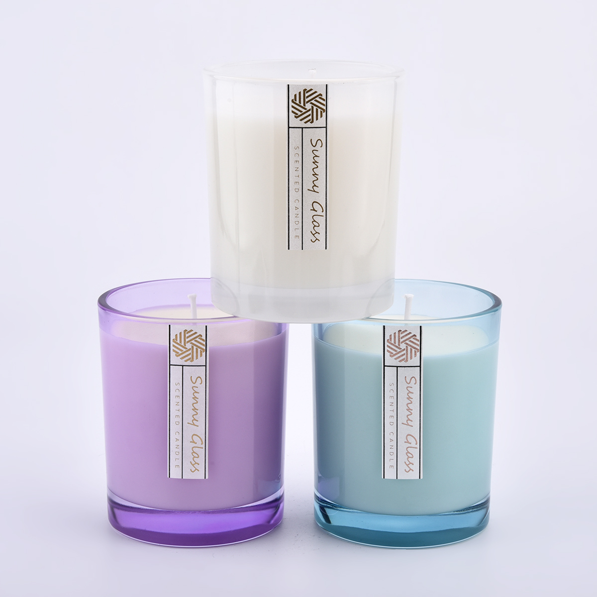 Frascos de vela de cristal en color y etiquetas transparentes personalizadas.