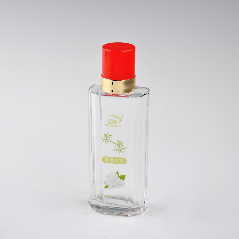 botella de perfume de cristal con la tapa de color rojo