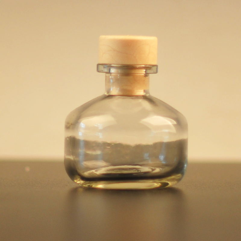 bottiglia di profumo di vetro con coperchio in legno